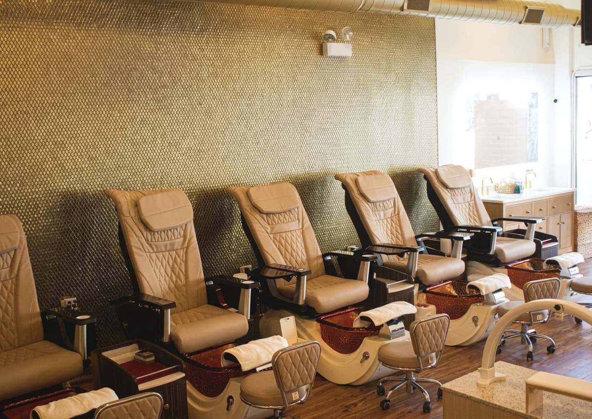 Champagne gold mosaic wall and cream pedicure chairs in the salon
